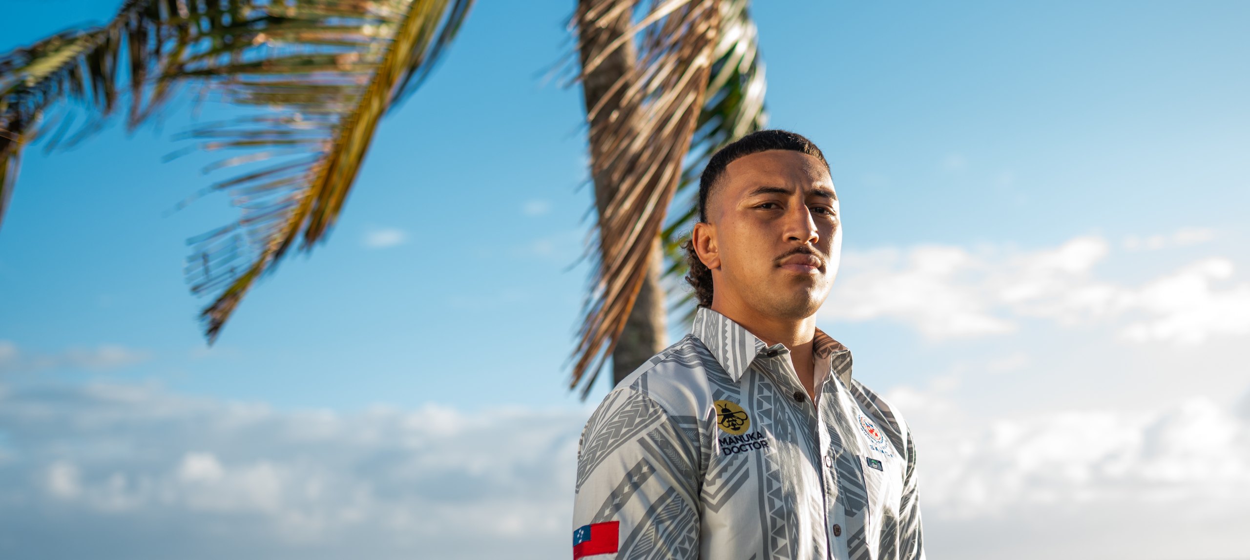 Toa Samoa player wearing the Eveni Pacific Toa Samoa Elei shirt on the Samoan coastline